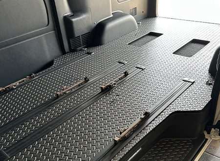 ペットの安全で快適な移動をサポートするカスタム車両の室内。収納棚と複数のペット用ケージが設置された空間